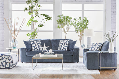 Dark navy blue sofa and loveseat set with geometric accent pillows in a bright modern living room