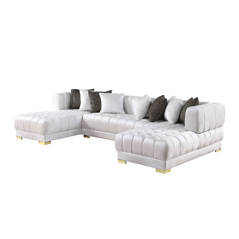 White velvet sectional sofa with gold legs and accent pillows in a modern living room