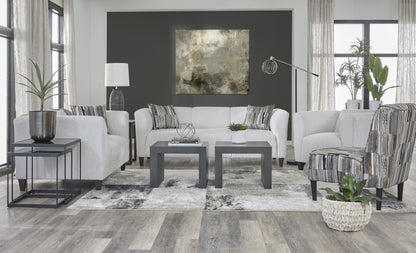 “Light gray contemporary sofa and loveseat set with curved arms and gray patterned throw pillows.