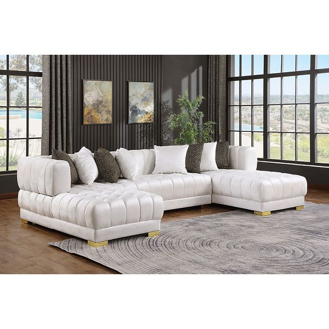 White velvet sectional sofa with gold legs and accent pillows in a modern living room