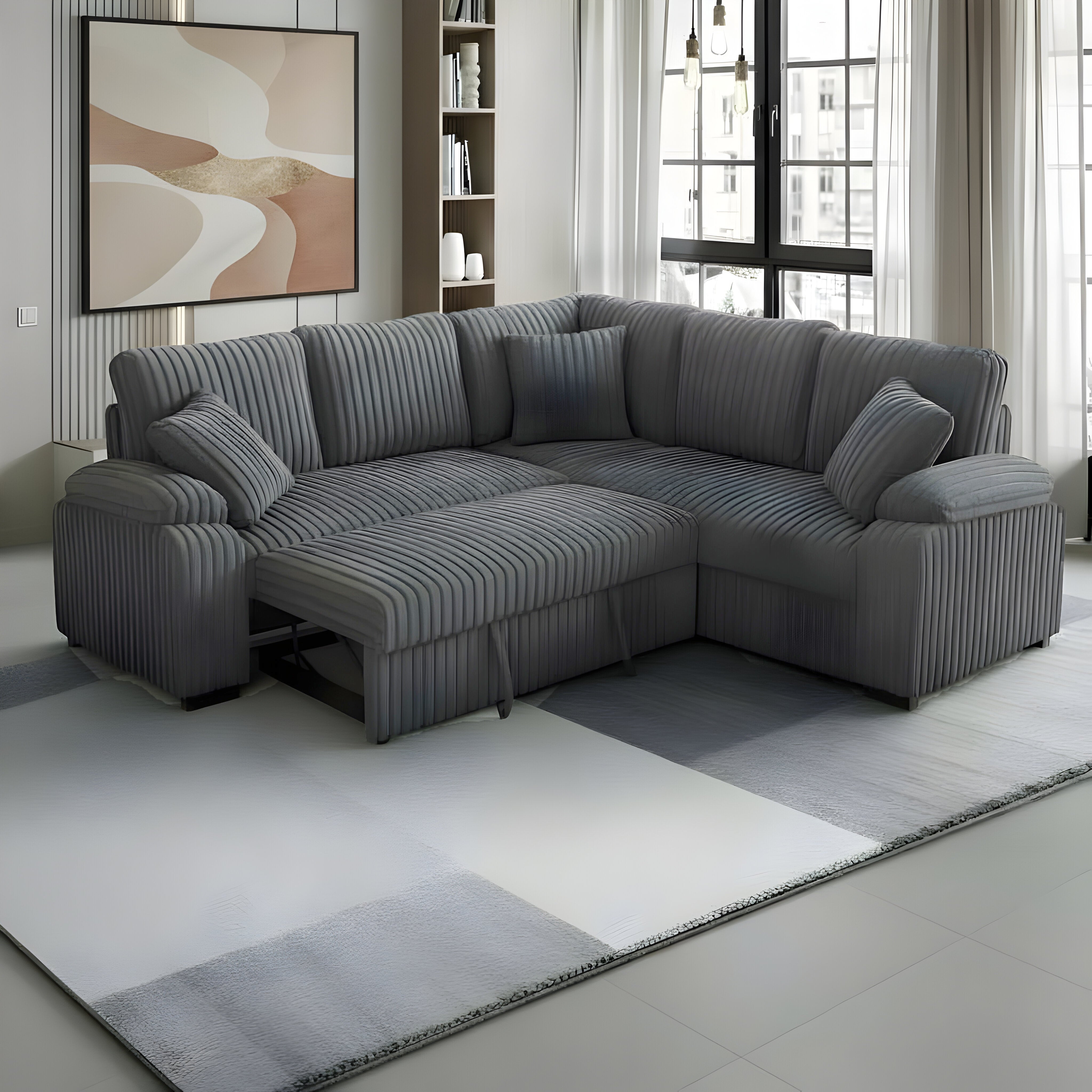 Grey corduroy sectional sofa with pullout bed and matching pillows in a modern living room