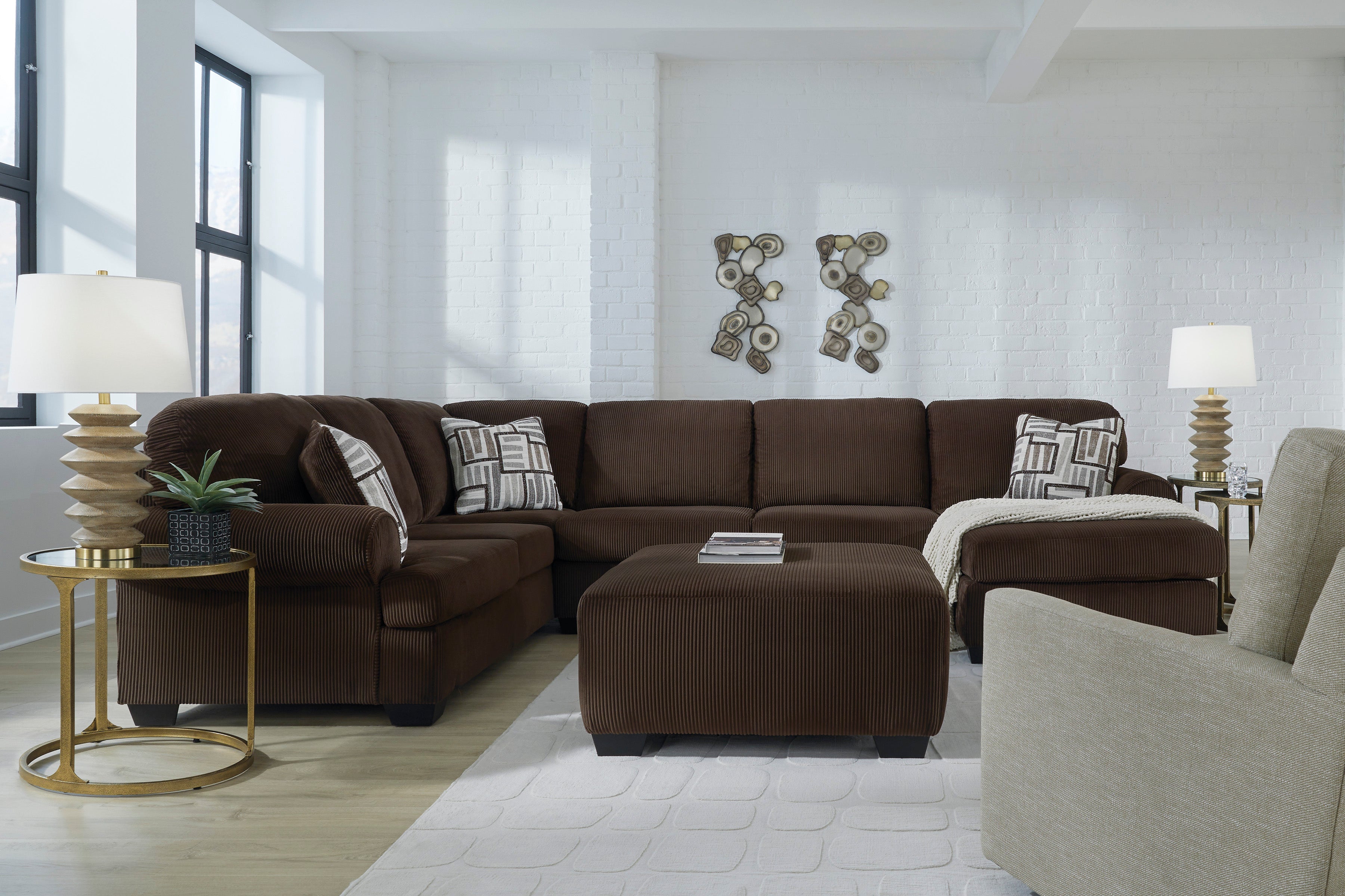 Chocolate brown transitional sectional sofa with corner chaise and matching ottoman in a living room setting