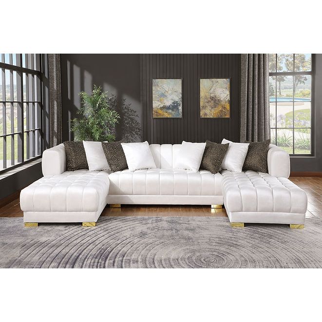 White velvet sectional sofa with gold legs and accent pillows in a modern living room