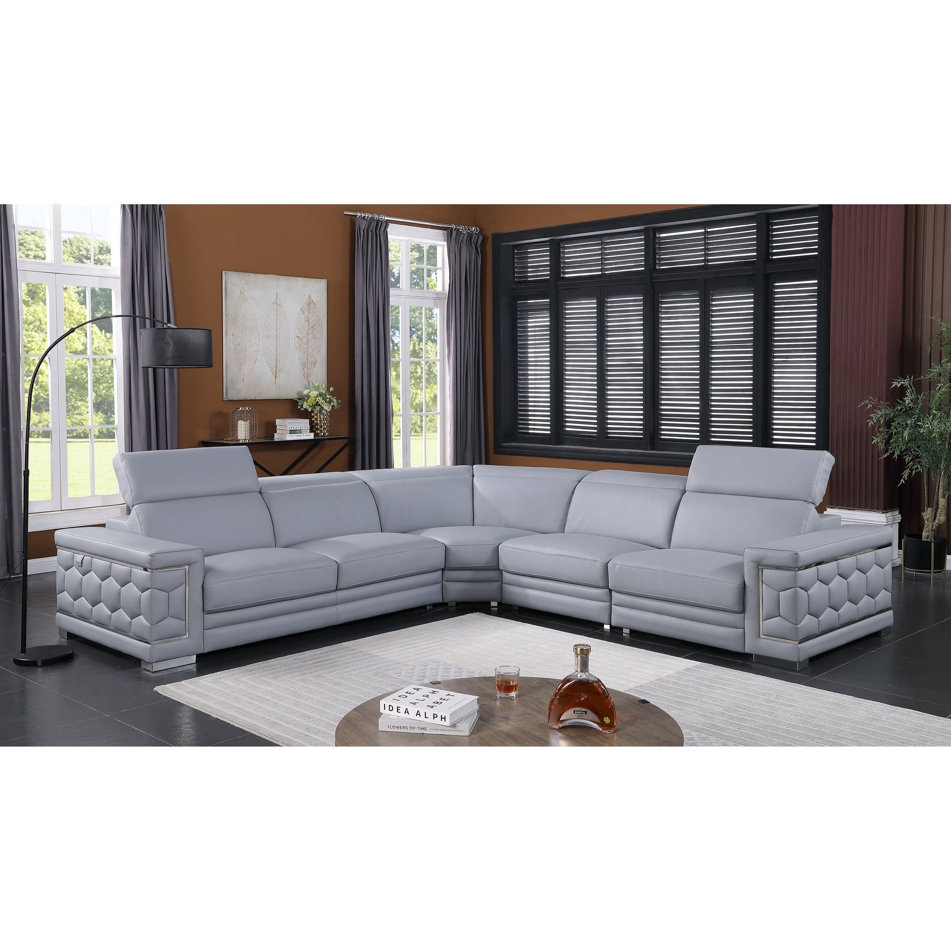 Favo 4-piece light blue-grey Italian leather sectional sofa with hexagon-tufted arms and chrome trim in a modern living room