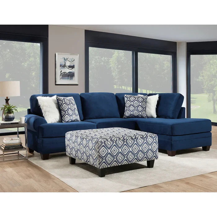 Blue sectional sofa with patterned ottoman in a living room setting.