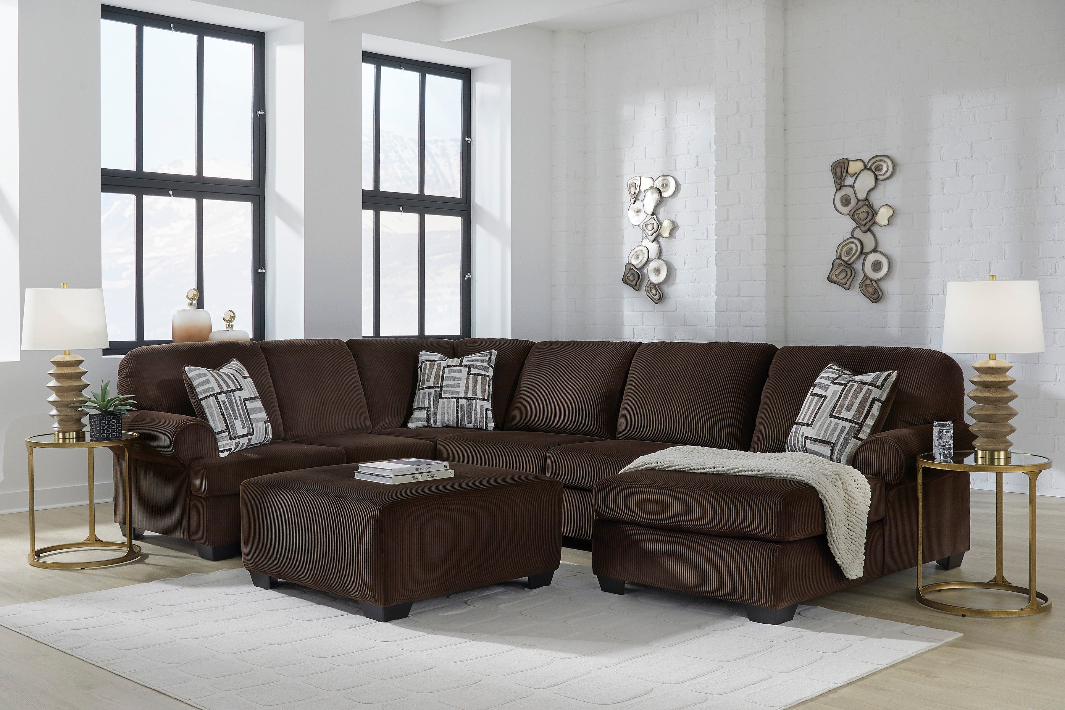 Chocolate brown transitional sectional sofa with corner chaise and matching ottoman in a living room setting
