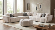 Beige fabric channel-tufted sectional sofa with round ottoman and accent pillows in a modern living room