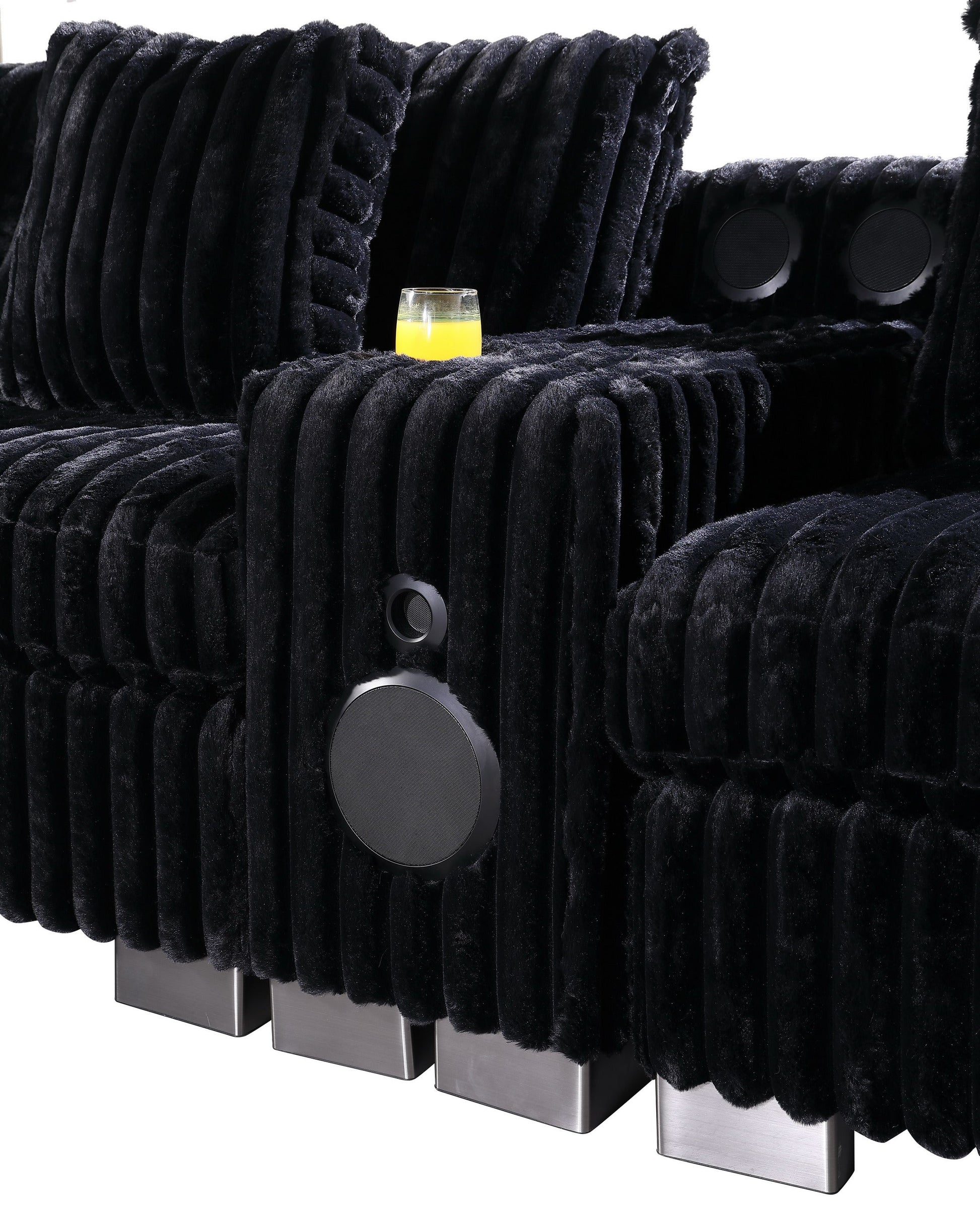 Black textured sectional sofa with Bluetooth console, ottoman, and stainless steel legs in a modern living room
