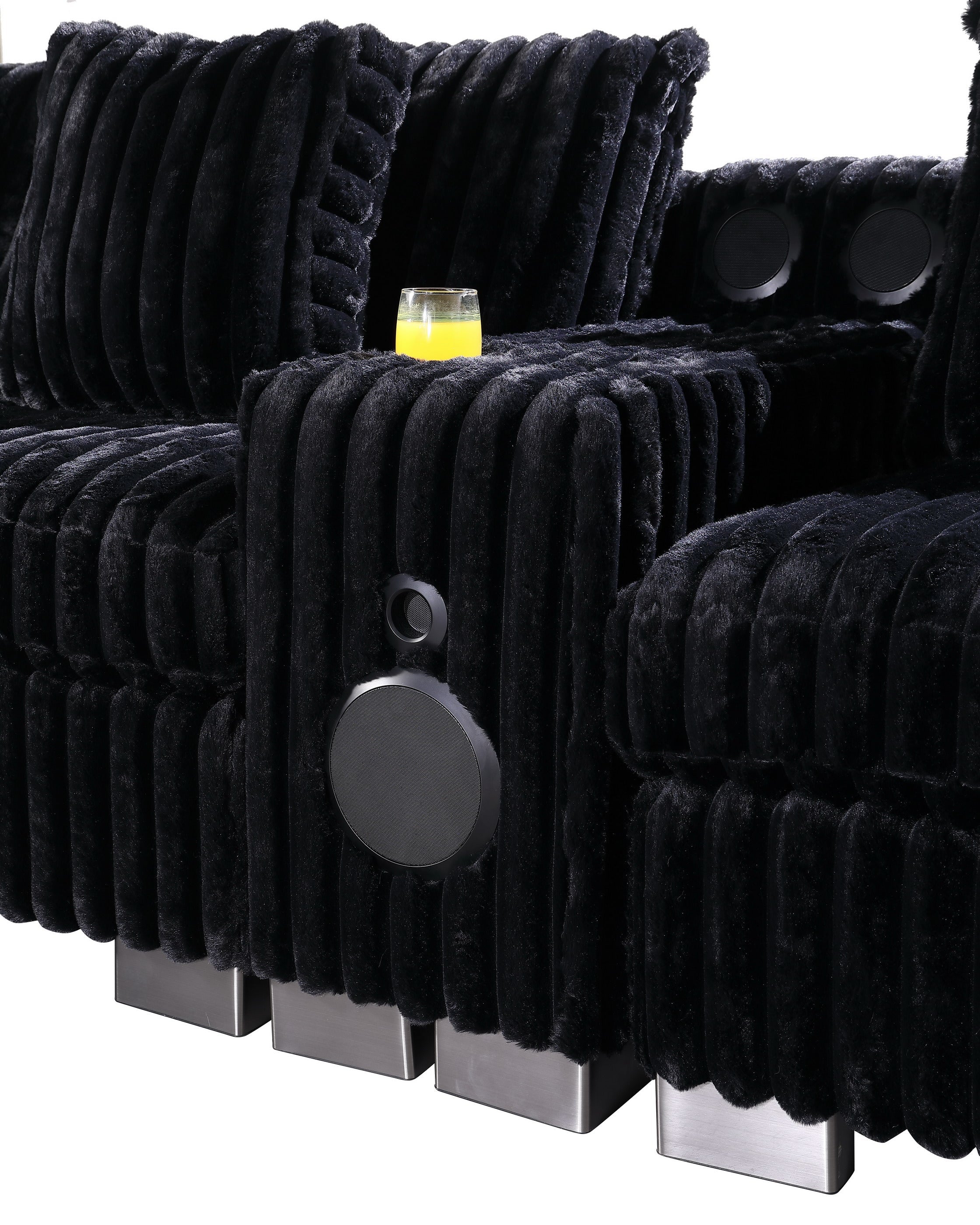 Black textured sectional sofa with Bluetooth console, ottoman, and stainless steel legs in a modern living room