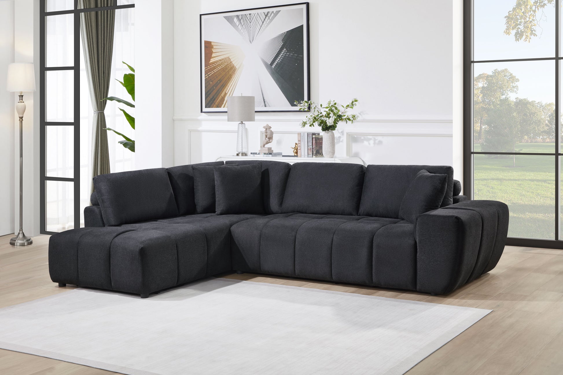Black low-profile L-shaped sectional sofa with vertical channel tufting in a modern living room