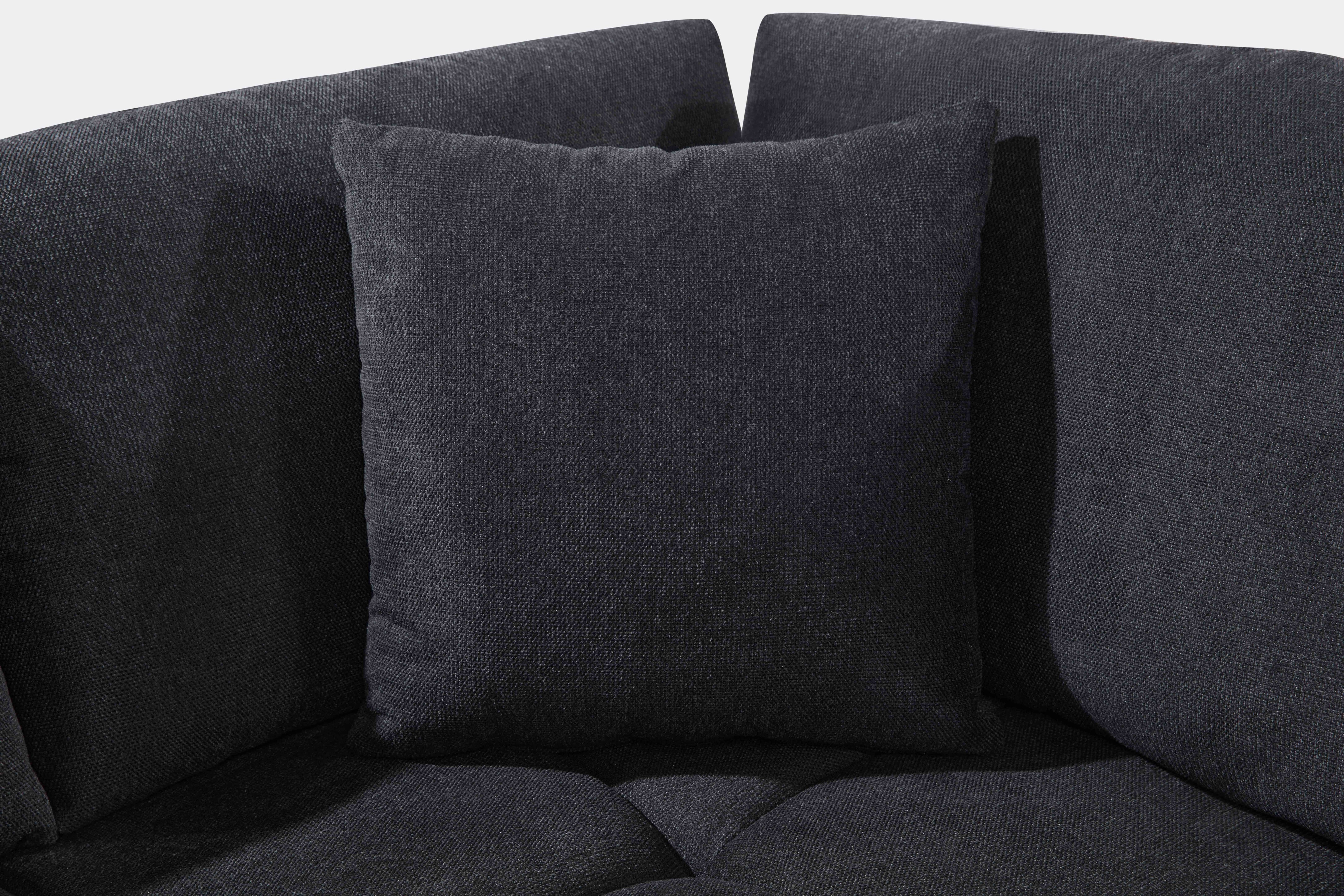 Black low-profile L-shaped sectional sofa with vertical channel tufting in a modern living room
