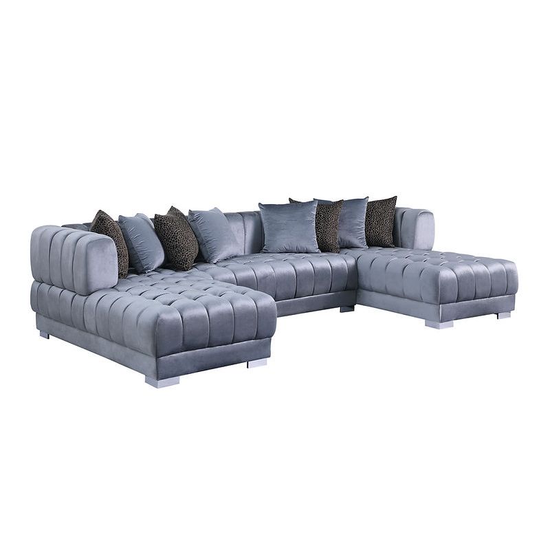 Grey velvet channel-tufted sectional sofa with silver legs and accent pillows