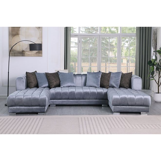 Grey velvet channel-tufted sectional sofa with silver legs and accent pillows