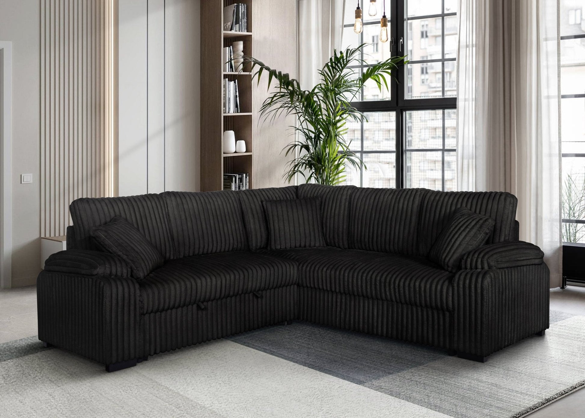 Black corduroy sectional sofa with pullout bed and matching pillows in modern living room